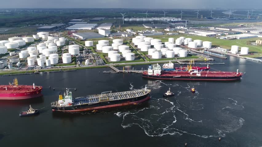 Aerial view of busy harbor area oil depot is an industrial facility for storage of petrochemical products showing tankers and tugs maneuvering the congested port waters 4k high resolution footage Royalty-Free Stock Footage #1026689819