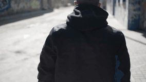 4k slow motion video, Man walks along the sidewalk in the city. Back view man in black clothes walking in old city alone.