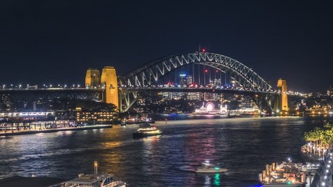 Timelapse video of Sydney Harbour Bridge at night, with bright city lights and ferries sailing in the harbour.