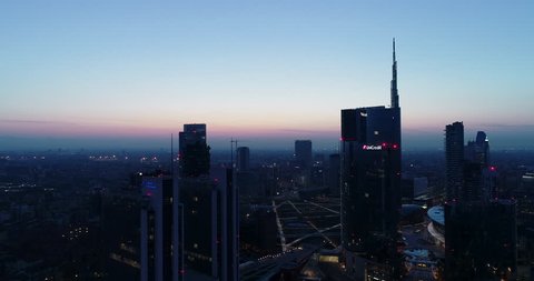 Milan, Italy - March 31, 2019: Milan city skyline at dawn, aerial view, flying over financial area skyscrapers in Porta Nuova district. Unicredit Tower office building at sunrise.