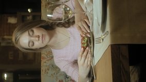 Vertical video. woman eats a sandwich with vegetables, drinks white wine in a restaurant. Bruschetta with tomatoes and avocado, vegetarian. portrait