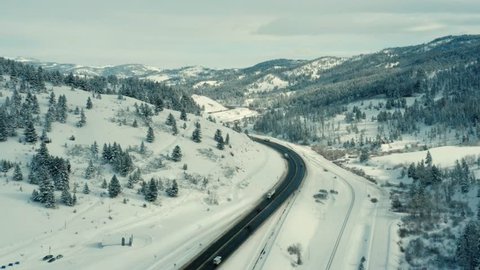 Aerial View Of Cars And Trucks Driving Down Highway 90 In Southwest Montana During Winter