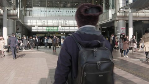 TOKYO, JAPAN - APRIL 1ST, 2019. Commuters walking at Shinagawa Railway Station in the morning hours. Color graded cinematic footage. Panning to the right.