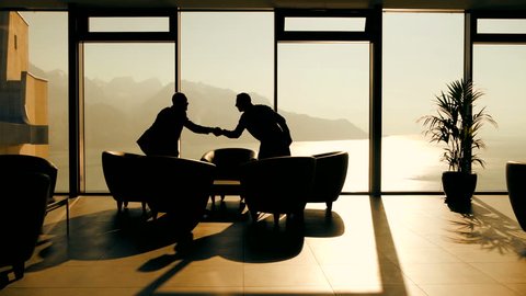 Two Business People Meeting in Modern Lobby Chatting Together