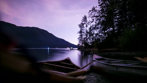 Starlapse of Canoes on a Calm Lake with Mountains and Trees