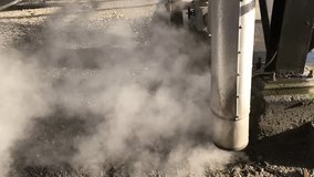 Steam pressure relief valve on a factory site. Slow motion video.