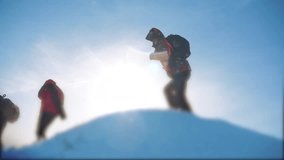 teamwork business concept slow motion video. group team tourist hikers gives climb to the top of the mountain. success win winter reached the top of the mountain. tourists climbers climb to the top of