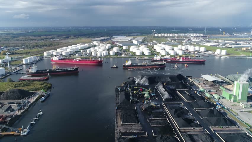 Aerial arriving at of busy harbor area oil depot is an industrial facility for storage of petrochemical products showing tankers and tugs maneuvering the congested port waters 4k high resolution Royalty-Free Stock Footage #1026763790