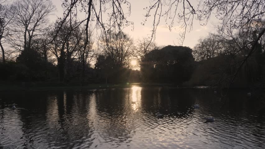 Sunburst reflected in pond at sunset