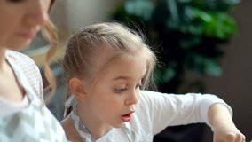 Close up. Mother daughter cooking together. Kid girl mixing dough in the bowl. Focus on the female hand, than on the kid girl face. - Powered by Shutterstock - Get 15% off with code: PIKWIZARD15