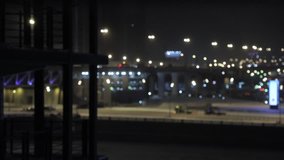 Pan shot left to right of moving cars traffic at night. Building works and defocused and blurred cars drive on the background. Blurred video, bokeh urban lights scene