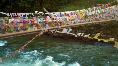 Suspension bridge covered in prayer flags near Paro, Bhutan