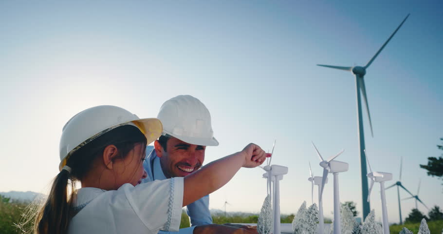 A father engineer shows his project to his daughter for the construction of a wind farm. The daughter is interested in renewable energy Royalty-Free Stock Footage #1026778994