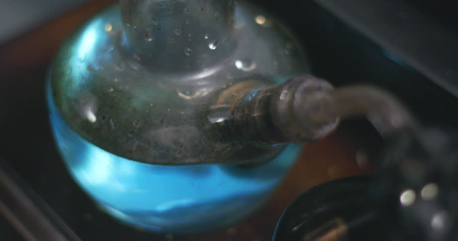 Bubbles and smoke in a dirty bong filled with blue flavored water. Close up. | Shutterstock HD Video #1026779549