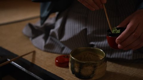 Japanese tea ceremony. Tea master puts powdered green tea, matcha, in a cup (chawan)