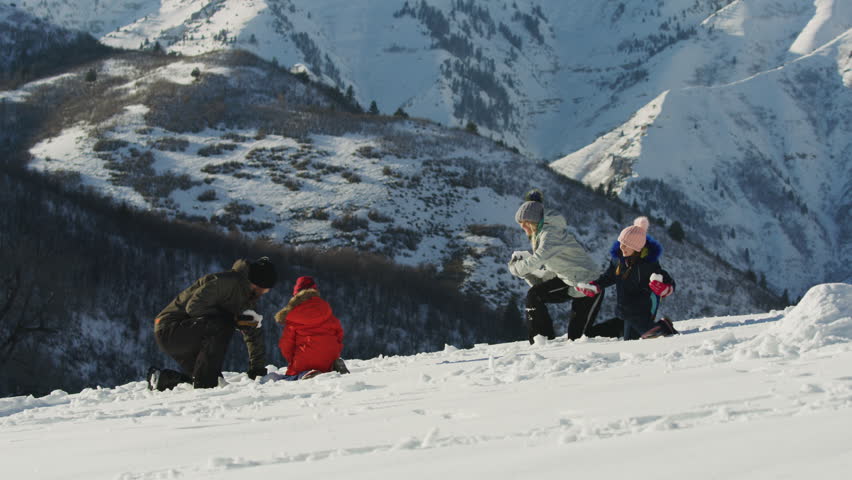 Slow motion of family having snowball fight near mountain / South Fork, Utah, United States