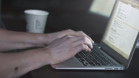 Male hands writing code and taking a cup of coffe from table. Hacker api text on the computer screen. Coding hacker concept. Modern tech.