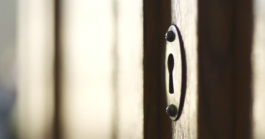 Side wiev of person by hand turns old key in the keyhole of antique wooden cabinet Royalty-Free Stock Footage #1026791822