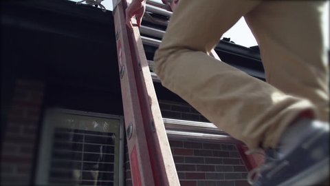 Roof inspector climbing metal ladder at suburban home to quote repairs