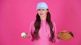 studio shoot of attractive happy young woman playing with baseball ball and glove