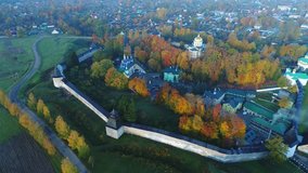 Over the old Svyato-Uspensky Pskovo-Pechersky monastery, October morning. Pechora, Russia (aerial video)  
