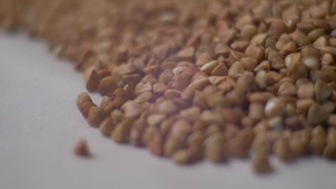 Rotating raw buckwheat. Buckwheat pours close-up. ?lose up dry uncooked seeds. Food video