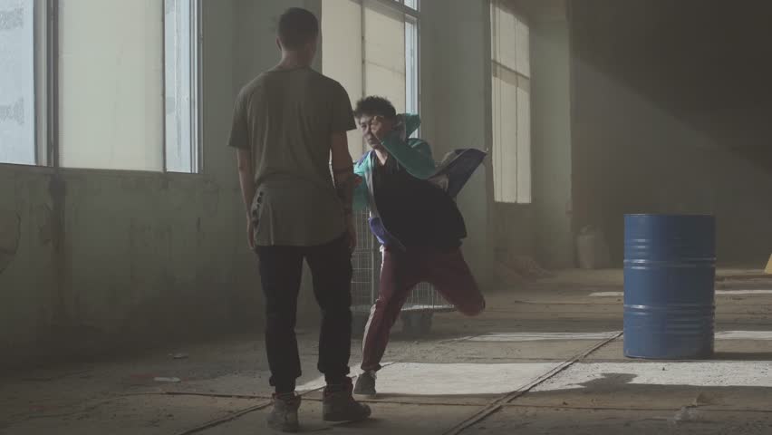 Hip hop culture. Rehearsal. Contemporary. Dance battle of two street dancers in an abandoned building near the barrel.