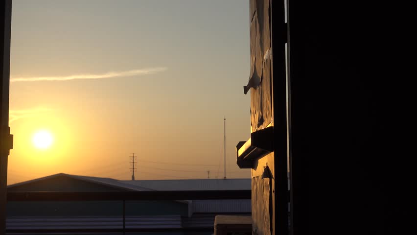 Asian men wearing glasses are going to stand by the balcony to relax after hard work at sunset in the evening.