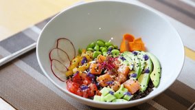 Footage of delicious fresh salad with salmon fish,sliced avocado,green beans and spice served in white bowl plate in cafe for lunch.Video of tasty natural food for healthy eating