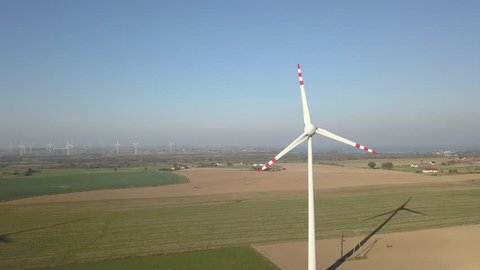 Landscape scenery with offshore windmills farm, filmed from a drone perspective. Windmills are located in nice agriculture area close to Puck city in Poland