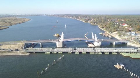 
The drawbridge is under construction. The bridge connects the two shores of Martwa Wis?a and is located near Sobieszewo, Poland. There are also yachts and other boats floating on the river.