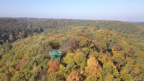 Aerial view to the forest landscape in autumn. Forest is a part of Tri-City Landscape Park. "Pacholek" mountain and view tower on top of this is also present in this footage.