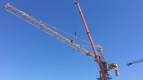Worker installing jib on a building crane. Industrial scene in 4k resolution