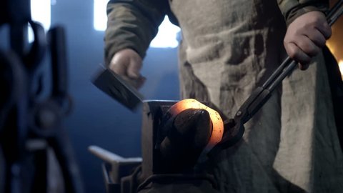 The blacksmith working in the forge, makes a horseshoe. Hand made, unique vintage technology. Rare old profession