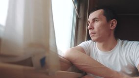 man rides train railway looks out lifestyle the window. traveler concept train railroad journey travel. slow motion video. beautiful from window of a moving train railway trip Russia winter