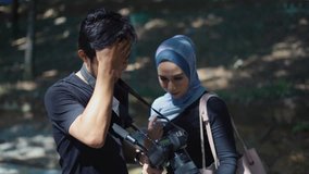 Young Muslim model looking at camera, review images playback with young man photographer after photoshoot session. - Powered by Shutterstock - Get 15% off with code: PIKWIZARD15