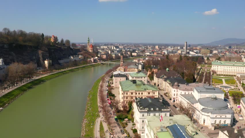Flying over the historic city of Salzburg with Salzach river, Salzburger Land, Austria. Aerial panoramic view with Alps on the background.