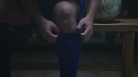 Soccer player wearing socks in locker room