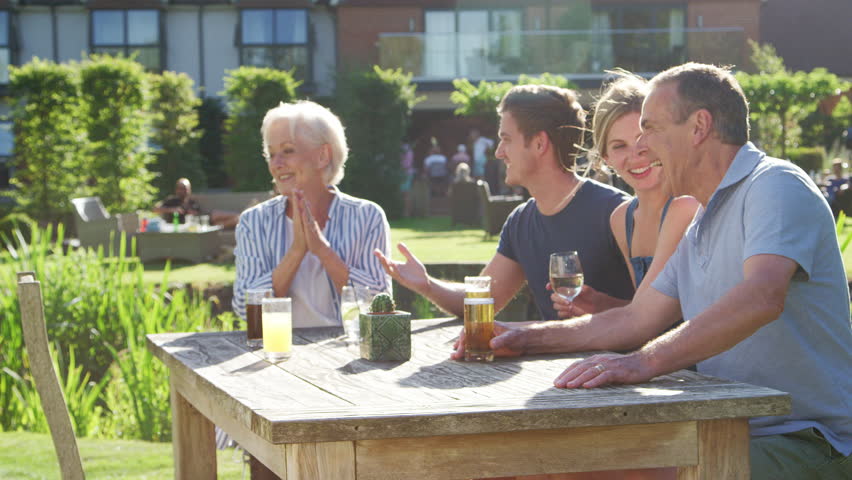 Multi Generation Family Enjoying Outdoor Summer Drink At Pub