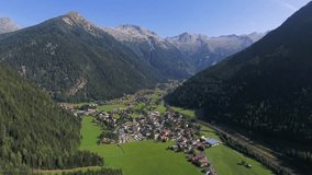 Drone footage of Mallnitz. Little town in the valley at a sunny summer day. Tilting down and moving forward drone clip of the valley