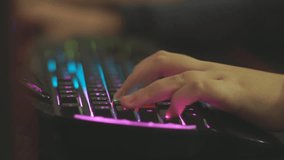 Close-up of a teenager's hand quickly presses buttons on the keyboard during online video games.