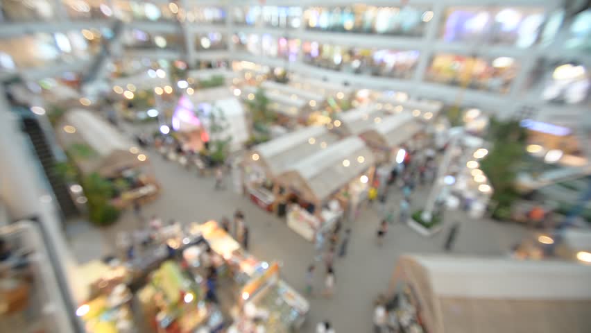 defocused crowd of walking people in the shopping mall center