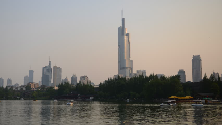 Time Lapse of Nanjing Skyline and Tourists People Ride Boat on Lake Sunset Light