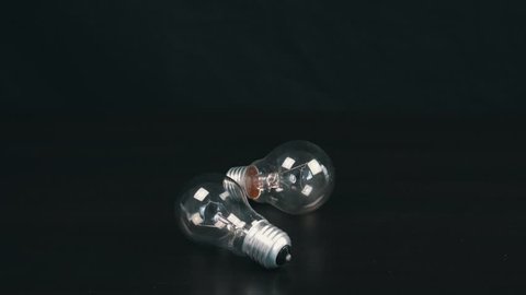Two light bulbs on black table