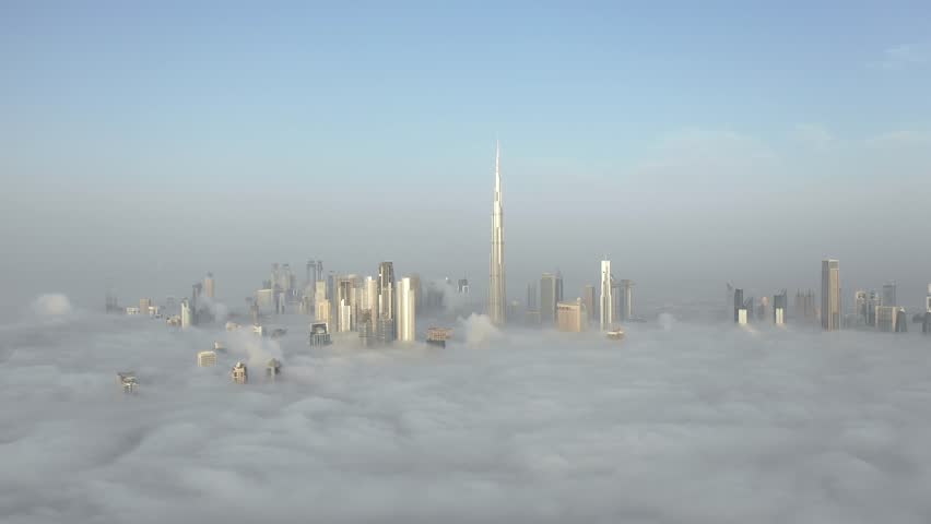 Aerial view of Dubai Downtown skyline being covered in winter morning fog - drone descending from great heights towards the fog. Dubai, UAE. | Shutterstock HD Video #1026875180