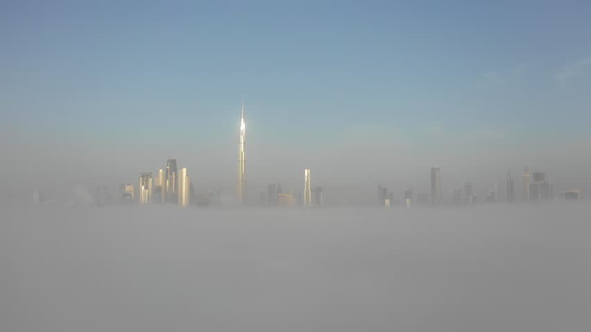 Aerial view of Dubai Downtown skyline being covered in winter morning fog - drone ascending through the fog to reveal the skyline. Dubai, UAE. | Shutterstock HD Video #1026875186