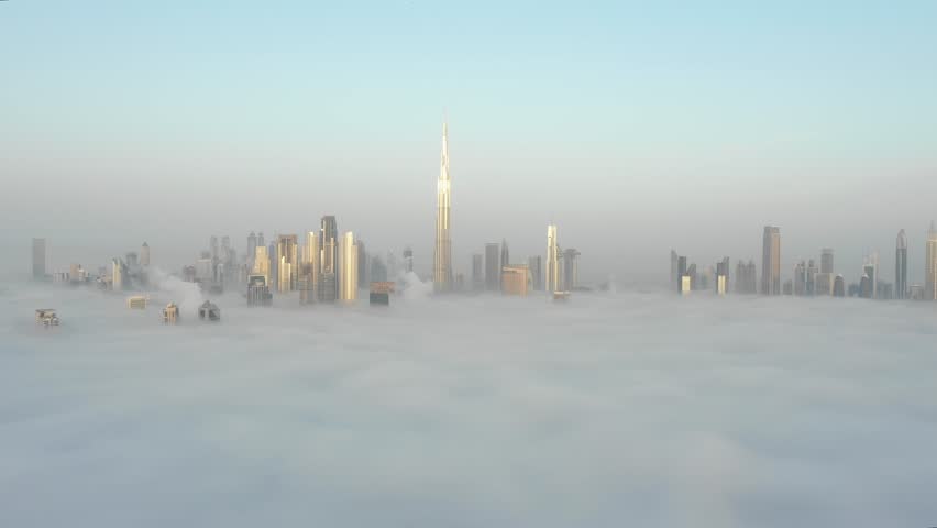 Aerial view of Dubai Downtown skyline being covered in winter morning fog - drone flying close towards the skyscrapers. Dubai, UAE. | Shutterstock HD Video #1026875189