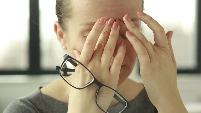 Feeling tired and stressed. Frustrated young woman keeping eyes closed and massaging nose while sitting at her working place in office. Young Businesswoman is tired and feels stressed out.    Royalty-Free Stock Footage #1026876809