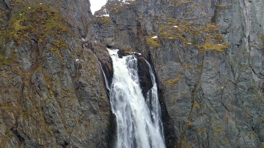 Snow pan down a large waterfall in the mountains of Norway on a winter day