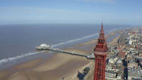Stunning aerial footage, view of Blackpool Tower by the award winning Blackpool beach, A very popular seaside tourist location in England , United Kingdom, UK
